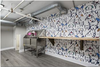 a room with a white wall with a dog drawing on it and a wooden table with a